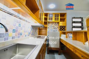 Modern kitchen with wooden cabinetry and colorful backsplash