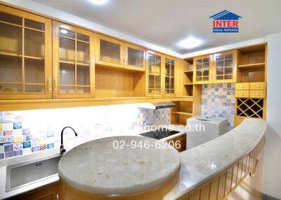 Modern kitchen with wooden cabinets and curved countertop