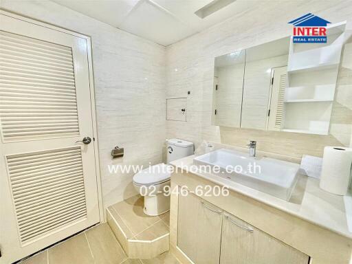 Clean and modern bathroom with sink, toilet, and mirror