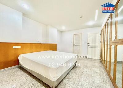 Bright and spacious bedroom with a large bed and built-in wardrobe