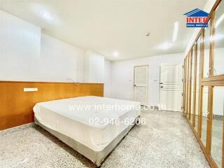 Bright and spacious bedroom with a large bed and built-in wardrobe