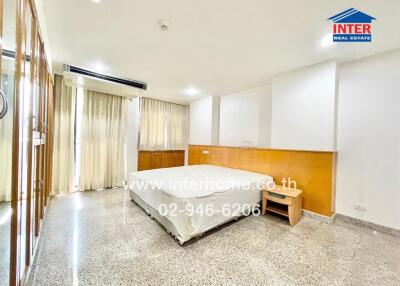 Spacious bedroom with large windows and ample natural light