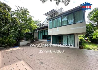 Exterior view of a modern house with large windows and lush greenery