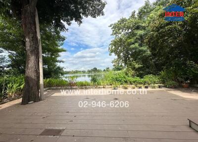 Spacious outdoor deck with a scenic view of a lake and surrounding greenery