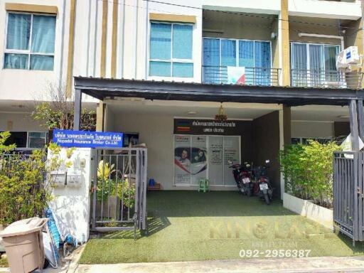 Front view of a multi-story residential building with a gated entrance