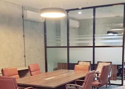 Modern office meeting room with wooden table and brown leather chairs