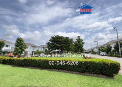 View of a residential neighborhood street with houses, green lawns, and trees