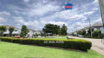 View of a residential neighborhood street with houses, green lawns, and trees