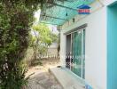 Outdoor area with sliding glass door and greenery