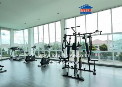 Modern gym with various exercise equipment and large windows