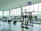 Modern gym with various exercise equipment and large windows