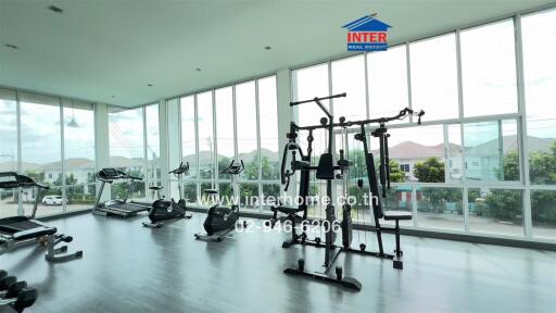 Modern gym with various exercise equipment and large windows