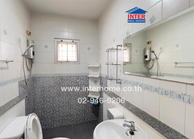 Modern bathroom with white tiles, sink, toilet, and shower