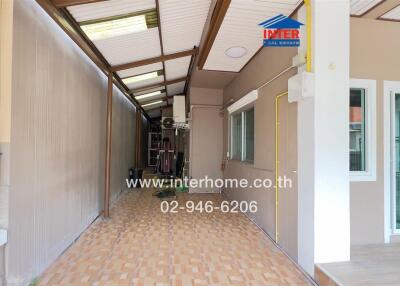 Outdoor hallway with a covered roof and tiled floor