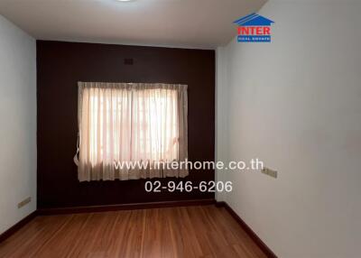 simple bedroom with window and wooden flooring