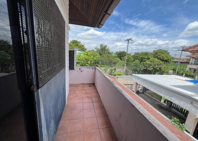 Outdoor balcony with tiled floor and view of surrounding neighborhood