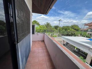 Outdoor balcony with tiled floor and view of surrounding neighborhood