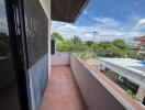 Outdoor balcony with tiled floor and view of surrounding neighborhood