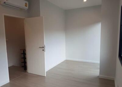 Empty, white-painted room with air conditioning and wooden floor