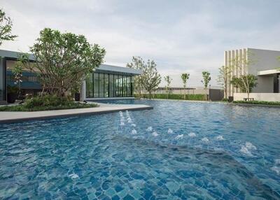 Large swimming pool with surrounding greenery and modern buildings