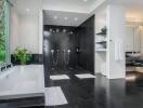 Modern bathroom with black-tiled walk-in shower and white bathtub