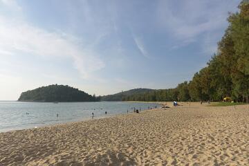 Scenic beach with trees and hills in the background