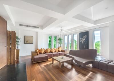 Spacious and bright living room with modern furniture and large windows.