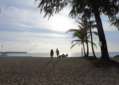 Beach view with people walking and palm trees