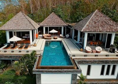 Aerial view of a luxurious villa with a pool and multiple outdoor seating areas