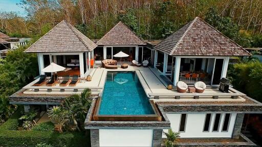 Aerial view of a luxurious villa with a pool and multiple outdoor seating areas