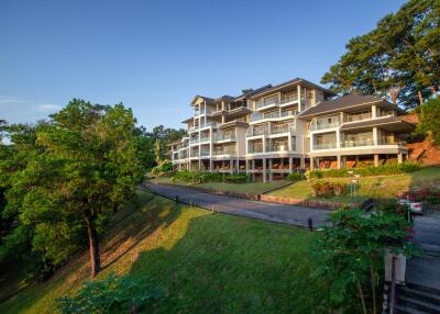 Exterior view of a modern multi-story residential building surrounded by greenery