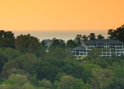 Scenic view of a residential building surrounded by lush greenery during sunset