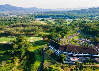 Aerial view of property surrounded by greenery and hills