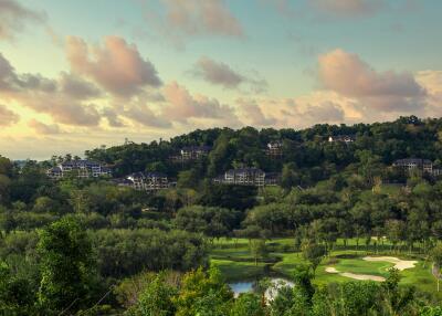 Scenic view of a lush green landscape with buildings in the distance