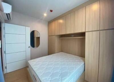 Bedroom with large built-in wooden wardrobe and mattress