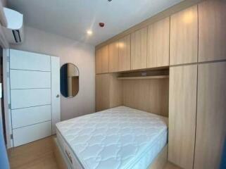 Bedroom with large built-in wooden wardrobe and mattress