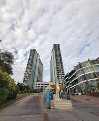 View of two high-rise residential buildings with entrance pathway