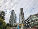 View of two high-rise residential buildings with entrance pathway