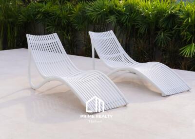 Outdoor lounging area with modern white chaise lounges