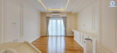 Spacious living room with hardwood flooring and large windows