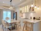 Modern kitchen and dining area with white cabinets and pendant lights