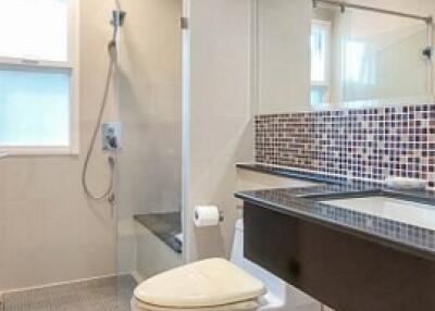 Modern bathroom with tiled walls and mirror