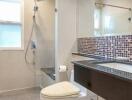 Modern bathroom with tiled walls and mirror