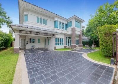 Exterior view of a modern two-story house with driveway and garden