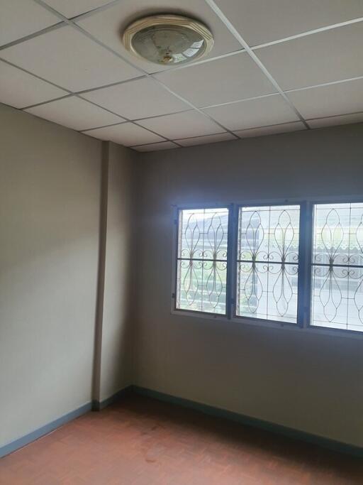 Empty bedroom with window and tiled ceiling