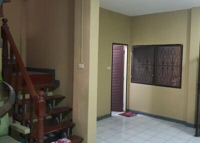 Staircase leading to the upper floor in a living room with tiled flooring and a window