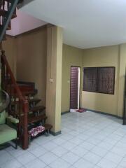 Staircase leading to the upper floor in a living room with tiled flooring and a window