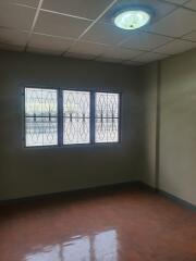 Empty bedroom with tiled ceiling and barred window