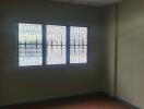 Empty bedroom with tiled ceiling and barred window