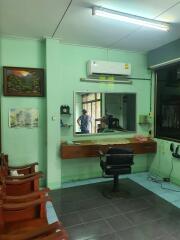 Salon or barbershop with a mirror, chairs, and an air conditioning unit